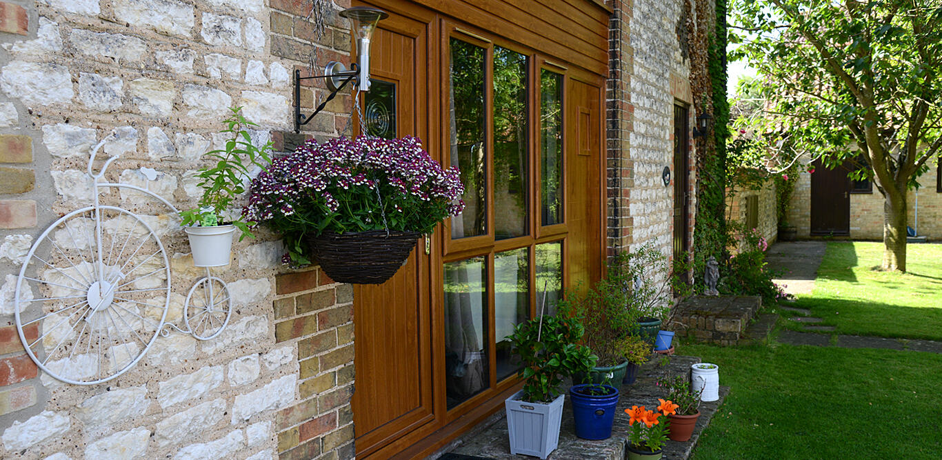 Flint wall with hanging basket and oak doors